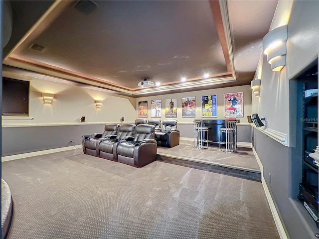 carpeted home theater featuring bar and a raised ceiling