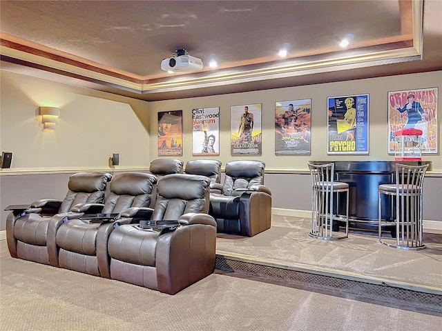 carpeted home theater with a tray ceiling and indoor bar