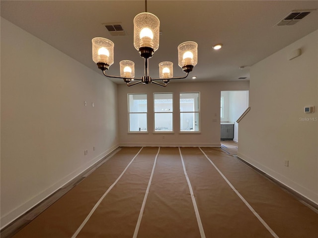 unfurnished dining area with a notable chandelier, baseboards, visible vents, and plenty of natural light