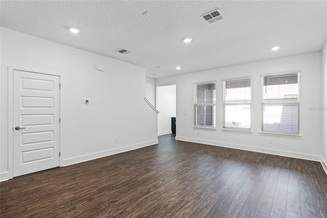 unfurnished room featuring baseboards, visible vents, recessed lighting, dark wood-type flooring, and a textured ceiling