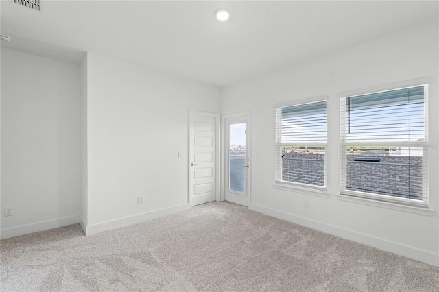 carpeted empty room featuring visible vents and baseboards