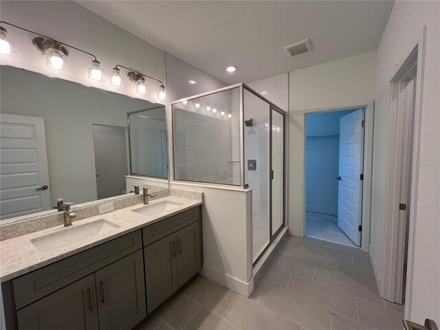 full bathroom with tile patterned flooring, visible vents, a stall shower, and a sink