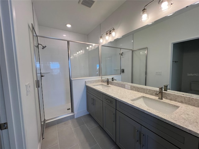 bathroom featuring a sink, visible vents, a stall shower, and double vanity