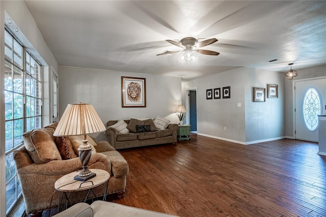 living room with dark wood-type flooring and ceiling fan