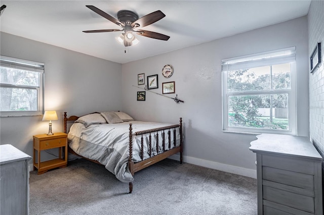 bedroom featuring ceiling fan, multiple windows, and light carpet