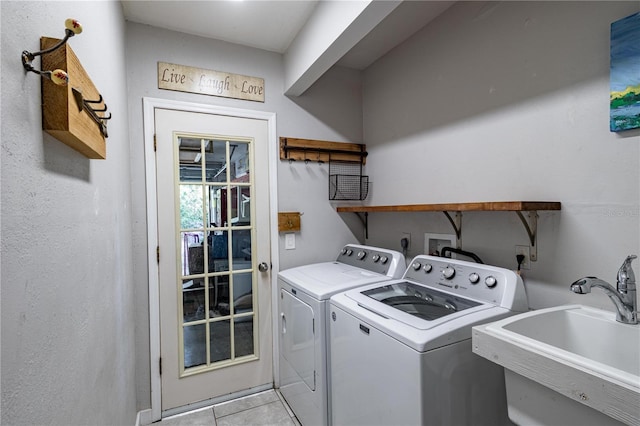 laundry room with light tile patterned flooring, sink, and washing machine and clothes dryer