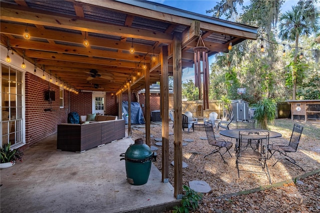 view of patio with ceiling fan, a storage unit, an outdoor hangout area, and grilling area