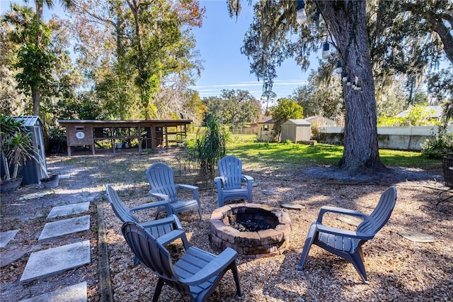 view of patio with a storage shed and a fire pit