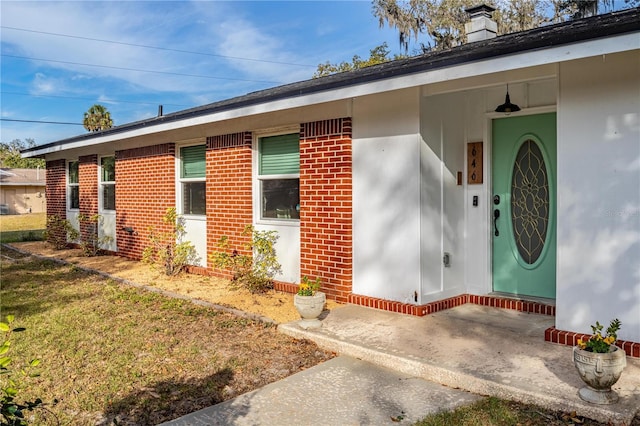 doorway to property featuring a lawn