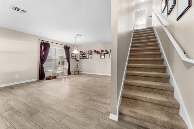 staircase with a textured ceiling