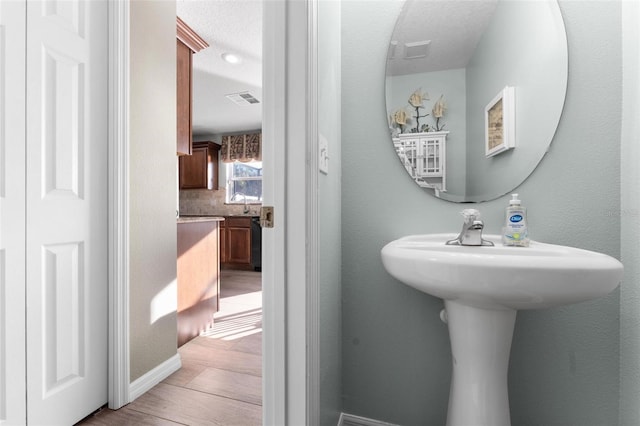 bathroom featuring sink, a textured ceiling, and backsplash