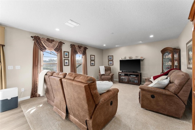 living room with a textured ceiling and light wood-type flooring