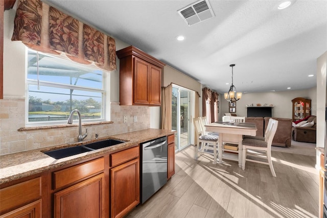 kitchen featuring sink, an inviting chandelier, decorative backsplash, stainless steel dishwasher, and light wood-type flooring