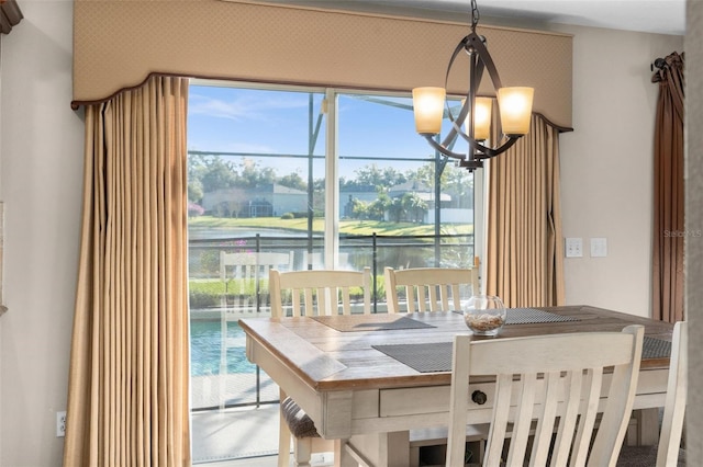 dining area featuring a water view and a chandelier