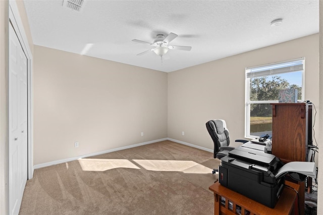 carpeted office featuring ceiling fan and a textured ceiling