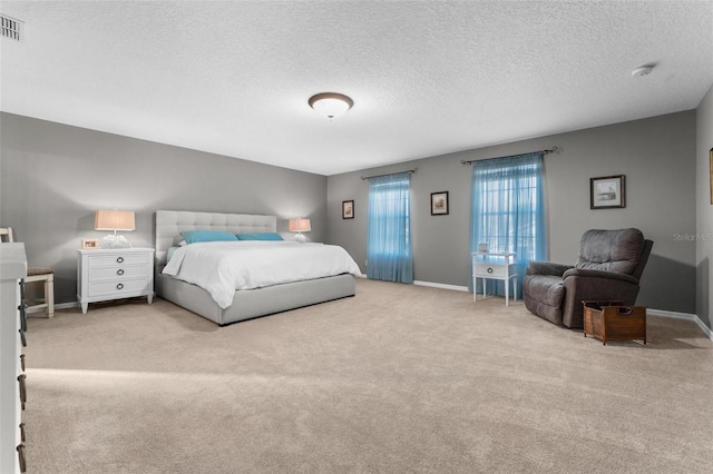 bedroom with light colored carpet and a textured ceiling