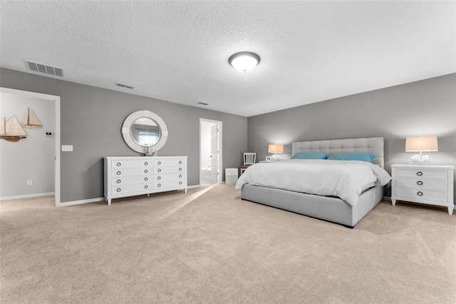 bedroom with light colored carpet and a textured ceiling