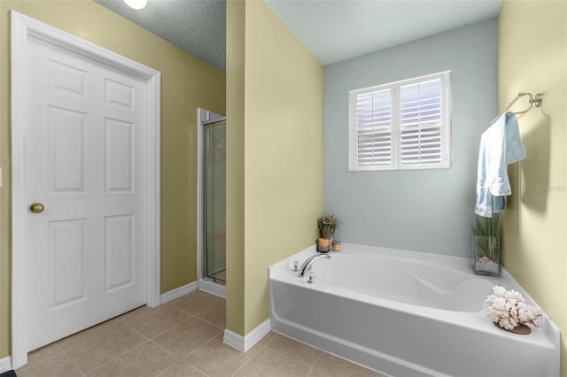 bathroom with shower with separate bathtub, tile patterned floors, and a textured ceiling