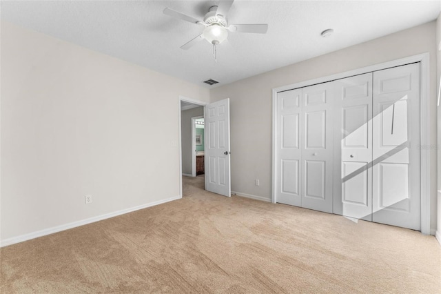 unfurnished bedroom featuring light colored carpet, ceiling fan, and a closet