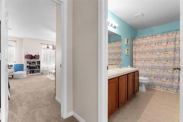 bathroom featuring walk in shower, vanity, toilet, and a textured ceiling