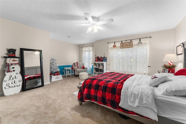 carpeted bedroom with ceiling fan and a textured ceiling