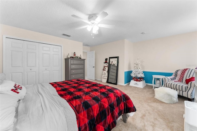 bedroom with a textured ceiling, a closet, ceiling fan, and carpet