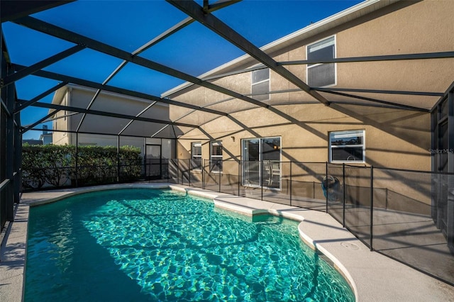 view of swimming pool featuring a patio area and glass enclosure