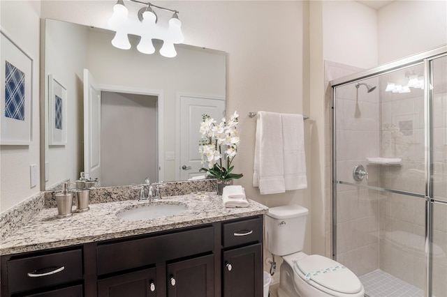 bathroom featuring vanity, toilet, and a shower with door