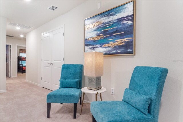 sitting room featuring light colored carpet