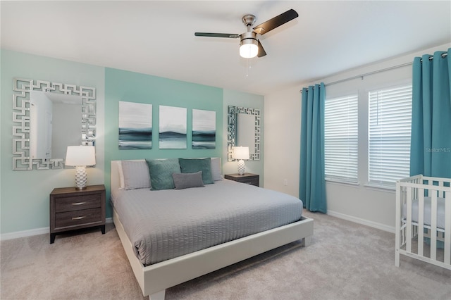 bedroom featuring ceiling fan, light colored carpet, and multiple windows