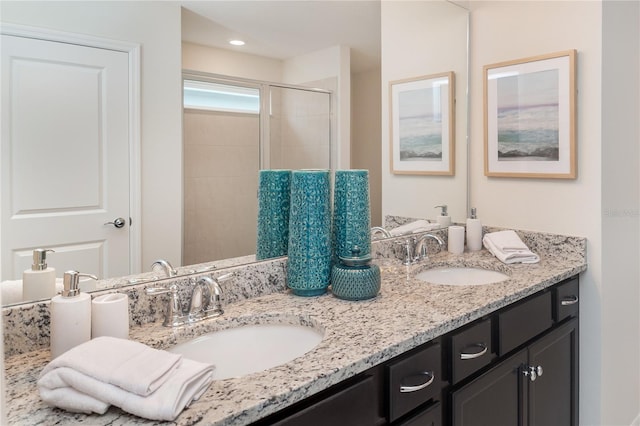 bathroom featuring a shower with door and vanity