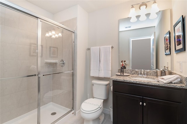 bathroom featuring vanity, a shower with shower door, tile patterned floors, and toilet