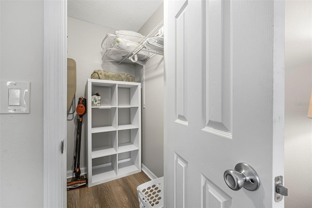 walk in closet with dark hardwood / wood-style flooring