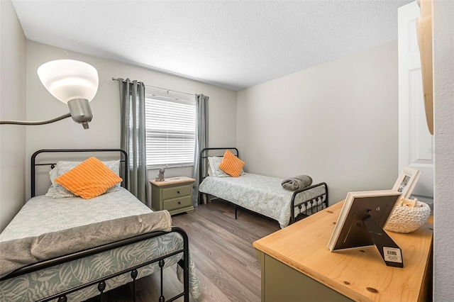 bedroom with a textured ceiling and light hardwood / wood-style floors