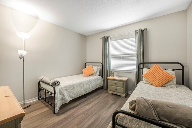 bedroom with hardwood / wood-style floors and a textured ceiling