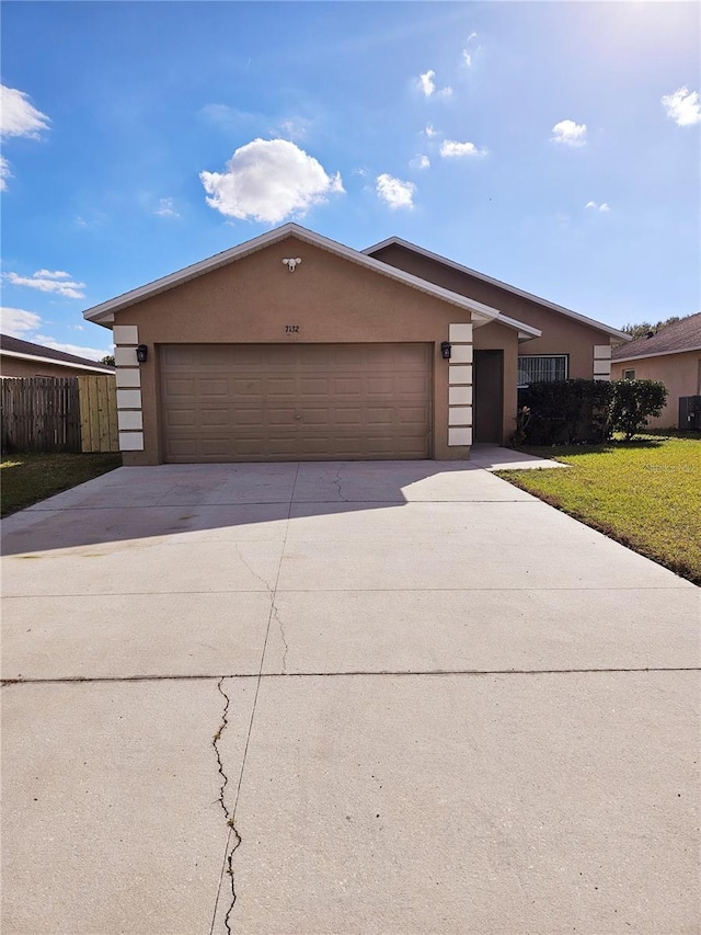 ranch-style home featuring a garage and a front lawn