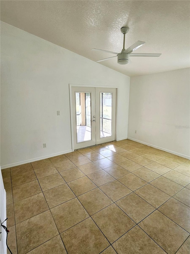 tiled empty room with ceiling fan, lofted ceiling, a textured ceiling, and french doors