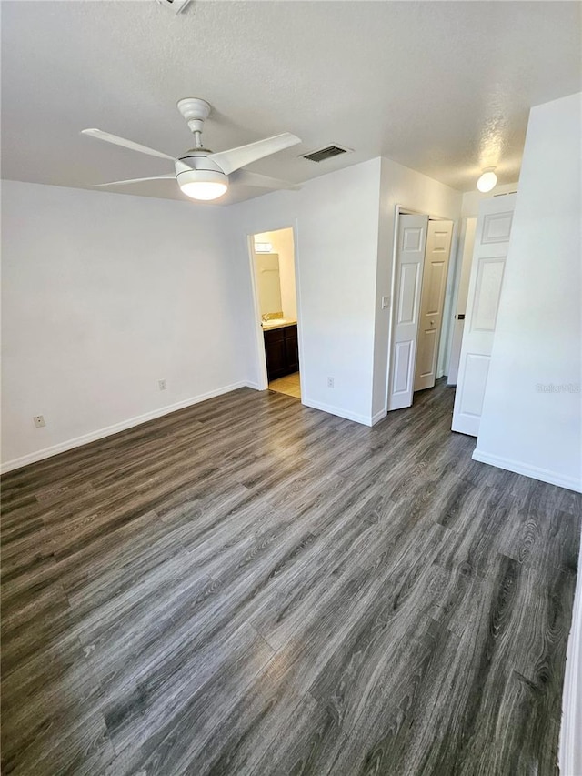 unfurnished room with ceiling fan, dark hardwood / wood-style floors, and a textured ceiling