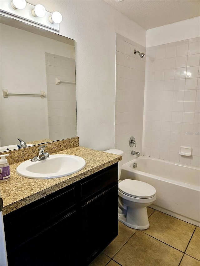 full bathroom with toilet, a textured ceiling, vanity, tiled shower / bath combo, and tile patterned flooring