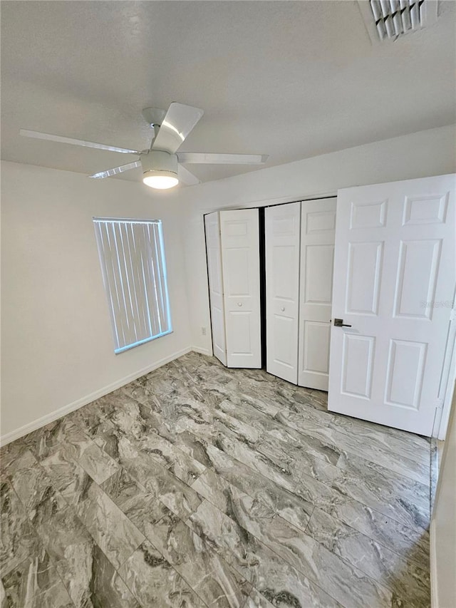 unfurnished bedroom with ceiling fan and a closet