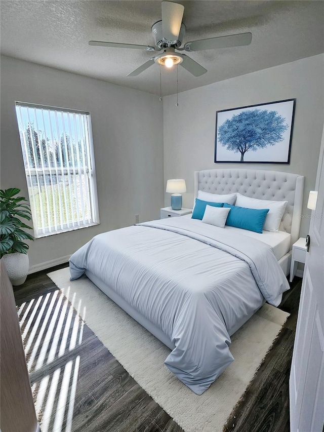 bedroom with ceiling fan, dark hardwood / wood-style flooring, and a textured ceiling