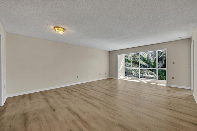 spare room featuring a textured ceiling and light wood-type flooring