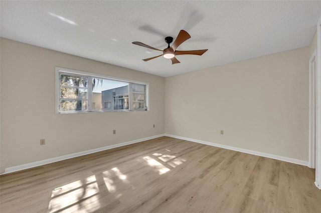 empty room with ceiling fan, light hardwood / wood-style flooring, and a textured ceiling