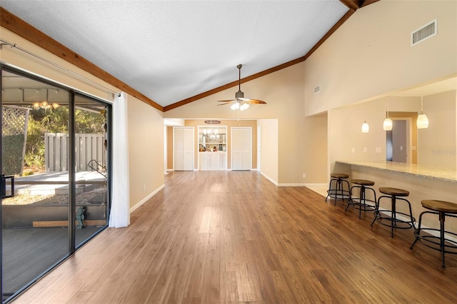 living room with vaulted ceiling, ceiling fan with notable chandelier, and hardwood / wood-style floors