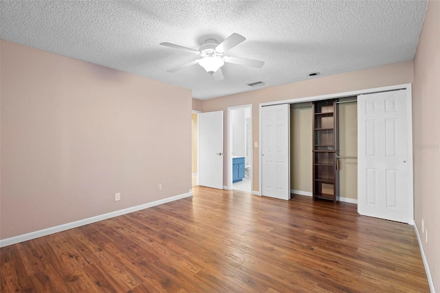 unfurnished bedroom featuring ceiling fan, dark hardwood / wood-style floors, a closet, and a textured ceiling