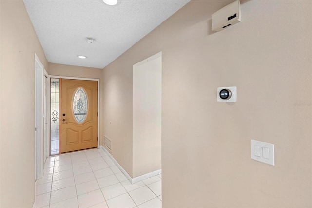 entryway featuring a textured ceiling and light tile patterned flooring