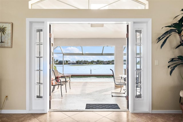 doorway with tile patterned flooring and a water view