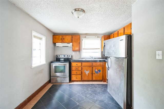 kitchen featuring stainless steel appliances, sink, and a textured ceiling