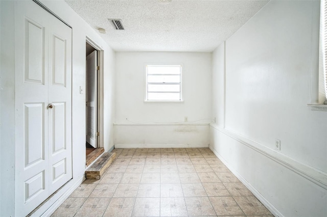 spare room with a textured ceiling