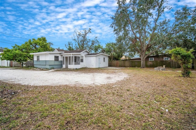 view of front of property featuring a sunroom and a front lawn